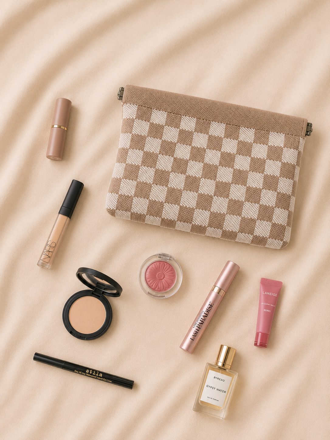 Better Lemonade checkered pouch on soft fabric with everyday essentials